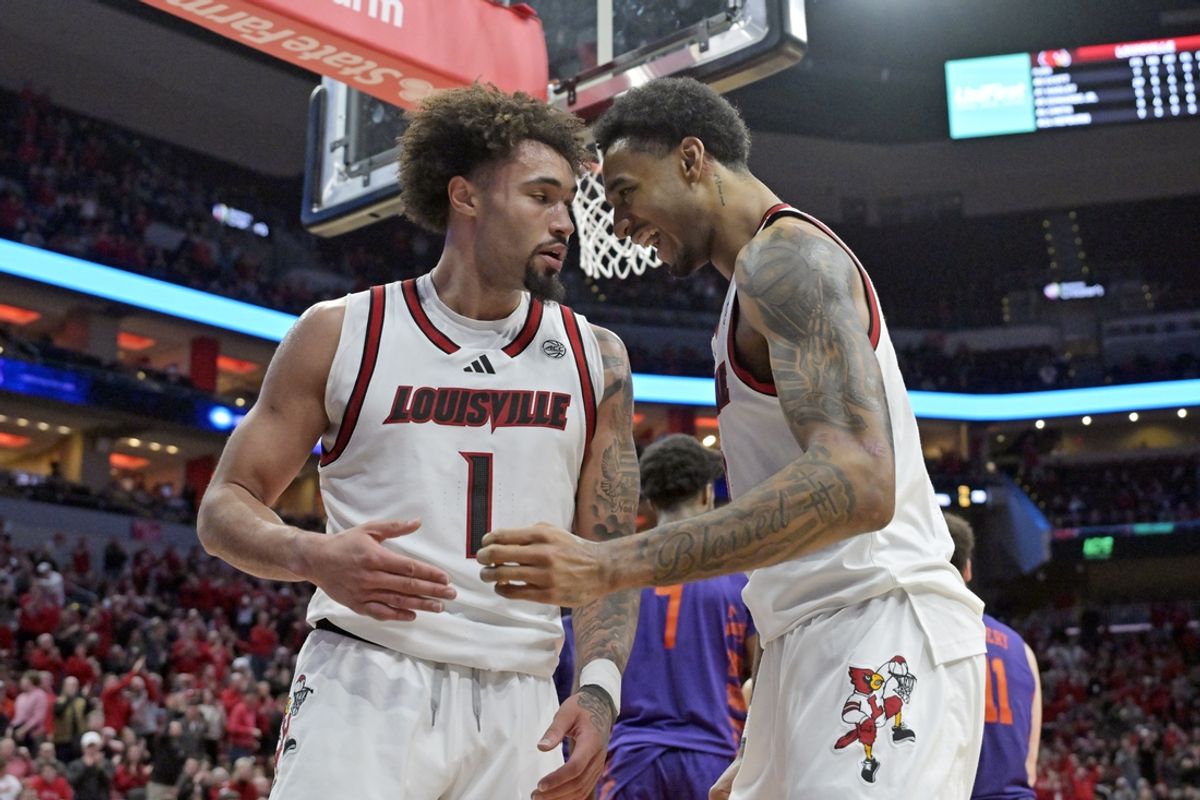Jan 7, 2025; Louisville, Kentucky, USA; Louisville Cardinals forward James Scott (0) celebrates with guard J'Vonne Hadley (1) during the second half against the Clemson Tigers at KFC Yum! Center. Louisville defeated Clemson 74-64. Mandatory Credit: Jamie Rhodes-Imagn Images