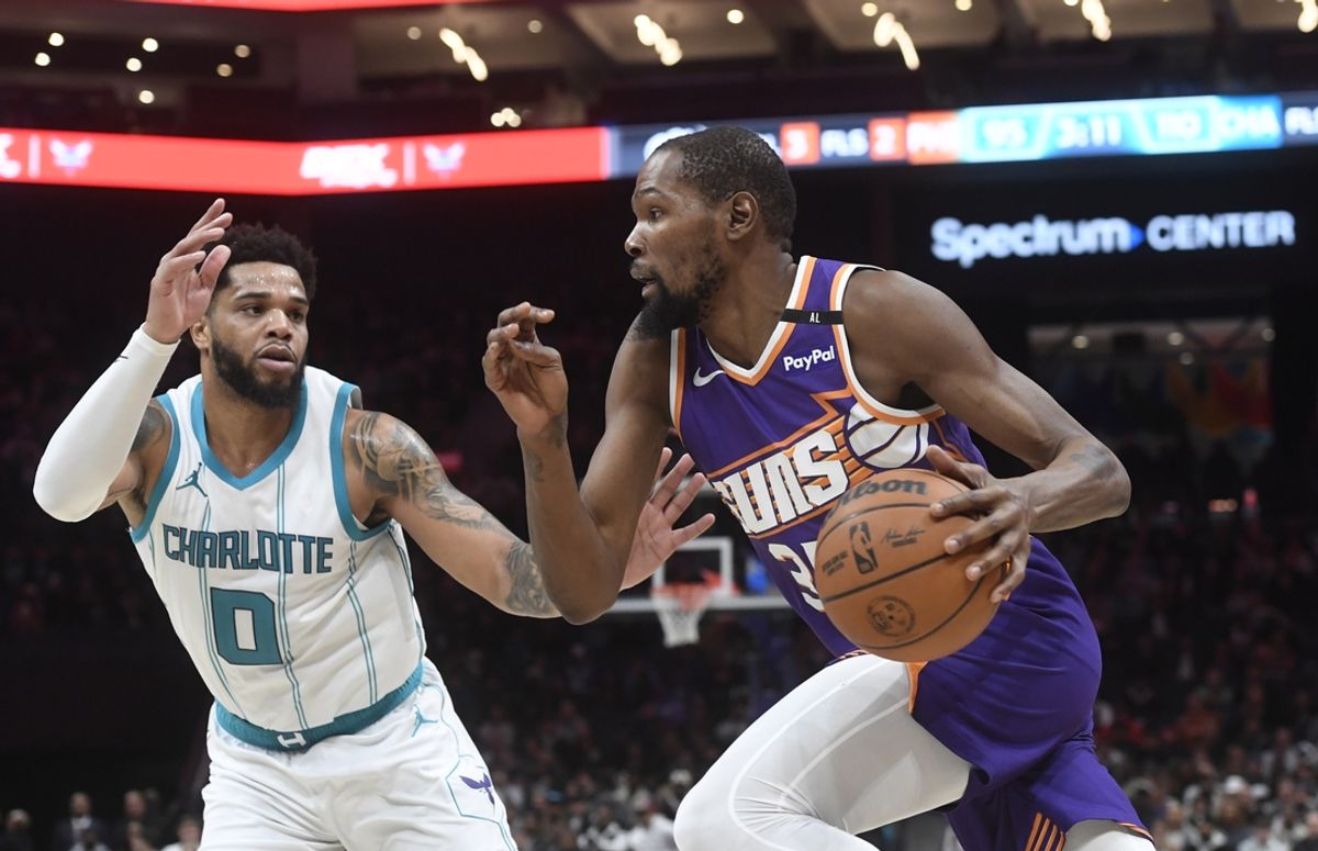 Jan 7, 2025; Charlotte, North Carolina, USA;  Phoenix Suns forward Kevin Durant (35) drives past Charlotte Hornets forward Miles Bridges (0) during the second half at the Spectrum Center. Mandatory Credit: Sam Sharpe-Imagn Images
