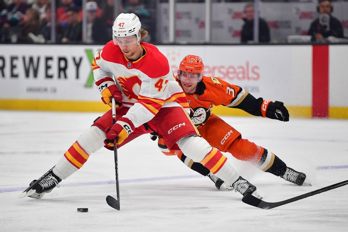 Jan 7, 2025; Anaheim, California, USA; Calgary Flames center Connor Zary (47) moves the puck ahead of Anaheim Ducks center Jansen Harkins (38) during the first period at Honda Center. Mandatory Credit: Gary A. Vasquez-Imagn Images
