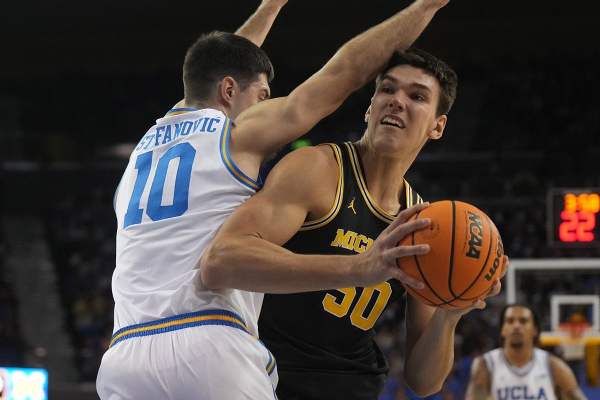 Jan 7, 2025; Los Angeles, California, USA; Michigan Wolverines center Vladislav Goldin (50) shoots the ball against UCLA Bruins guard Lazar Stefanovic (10) in the first half at Pauley Pavilion presented by Wescom. Mandatory Credit: Kirby Lee-Imagn Images