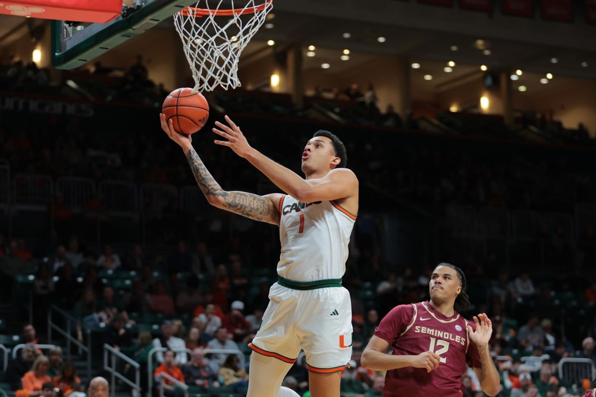 Jan 8, 2025; Coral Gables, Florida, USA; Miami Hurricanes center Lynn Kidd (1) drives to the basket past Florida State Seminoles forward Malique Ewin (12) during the second half at Watsco Center. Mandatory Credit: Sam Navarro-Imagn Images