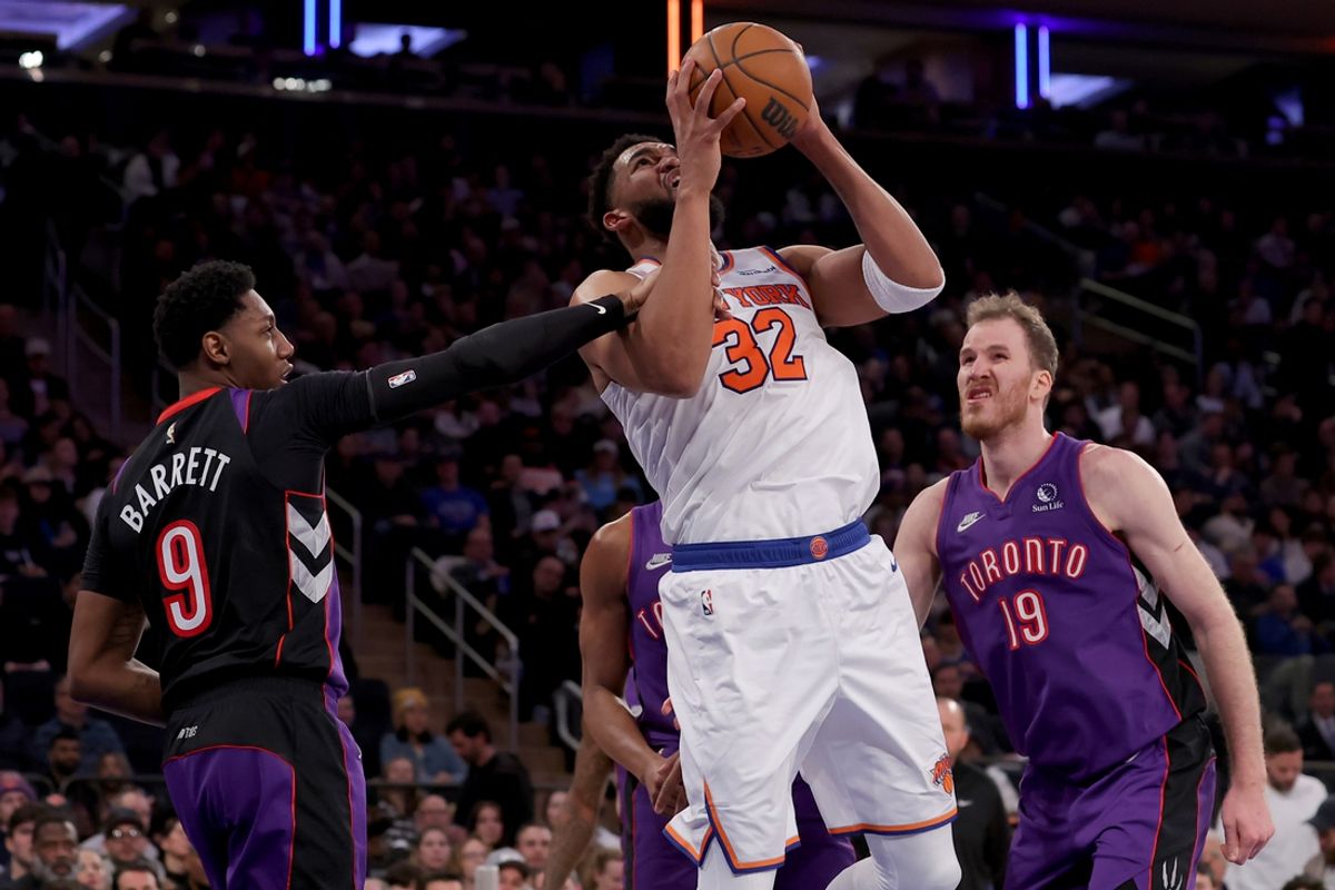 Jan 8, 2025; New York, New York, USA; New York Knicks center Karl-Anthony Towns (32) is fouled by Toronto Raptors guard RJ Barrett (9) as he drives to the basket against Raptors center Jakob Poeltl (19) during the third quarter at Madison Square Garden. Mandatory Credit: Brad Penner-Imagn Images