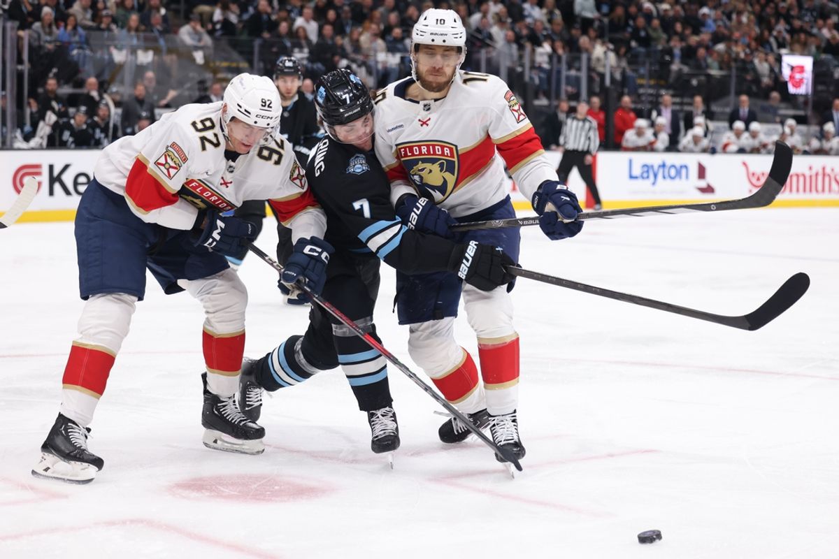 Jan 8, 2025; Salt Lake City, Utah, USA; Utah Hockey Club defenseman Michael Kesselring (7) reaches for the puck between Florida Panthers left wing Tomas Nosek (92) and Florida Panthers left wing A.J. Greer (10) during the first period at Delta Center. Mandatory Credit: Rob Gray-Imagn Images