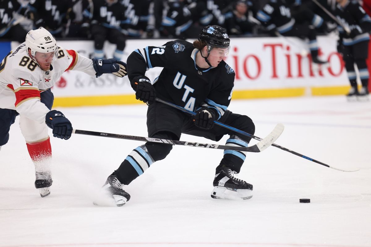 Jan 8, 2025; Salt Lake City, Utah, USA; Utah Hockey Club center Logan Cooley (92) skates with the puck against Florida Panthers defenseman Nate Schmidt (88) during the second period at Delta Center. Mandatory Credit: Rob Gray-Imagn Images