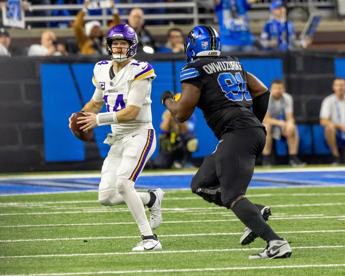 Jan 5, 2025; Detroit, Michigan, USA; Minnesota Vikings quarterback Sam Darnold (14) is pressured by Detroit Lions defensive end Levi Onwuzurike (91) during the second half at Ford Field. Mandatory Credit: David Reginek-Imagn Images