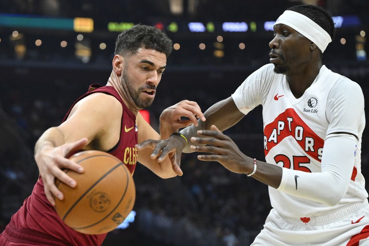 Jan 9, 2025; Cleveland, Ohio, USA; Cleveland Cavaliers forward Georges Niang (20) drives against Toronto Raptors forward Chris Boucher (25) in the first quarter at Rocket Mortgage FieldHouse. Mandatory Credit: David Richard-Imagn Images