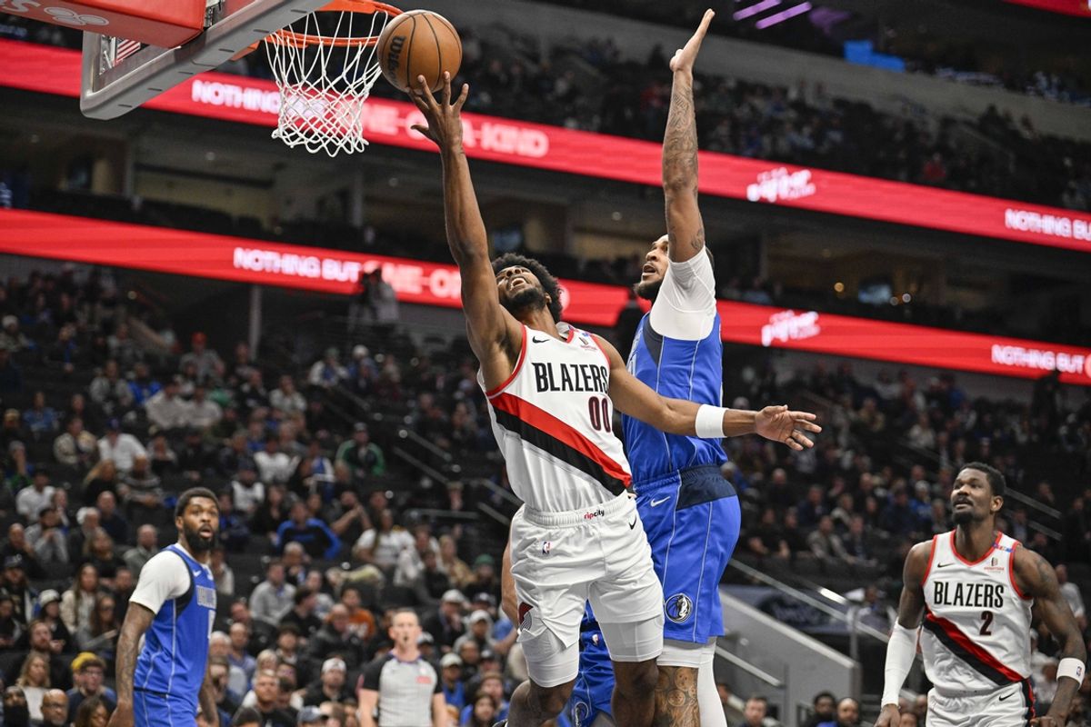 Jan 9, 2025; Dallas, Texas, USA; Portland Trail Blazers guard Scoot Henderson (00) drives to the basket past Dallas Mavericks center Daniel Gafford (21) during the second quarter at the American Airlines Center. Mandatory Credit: Jerome Miron-Imagn Images