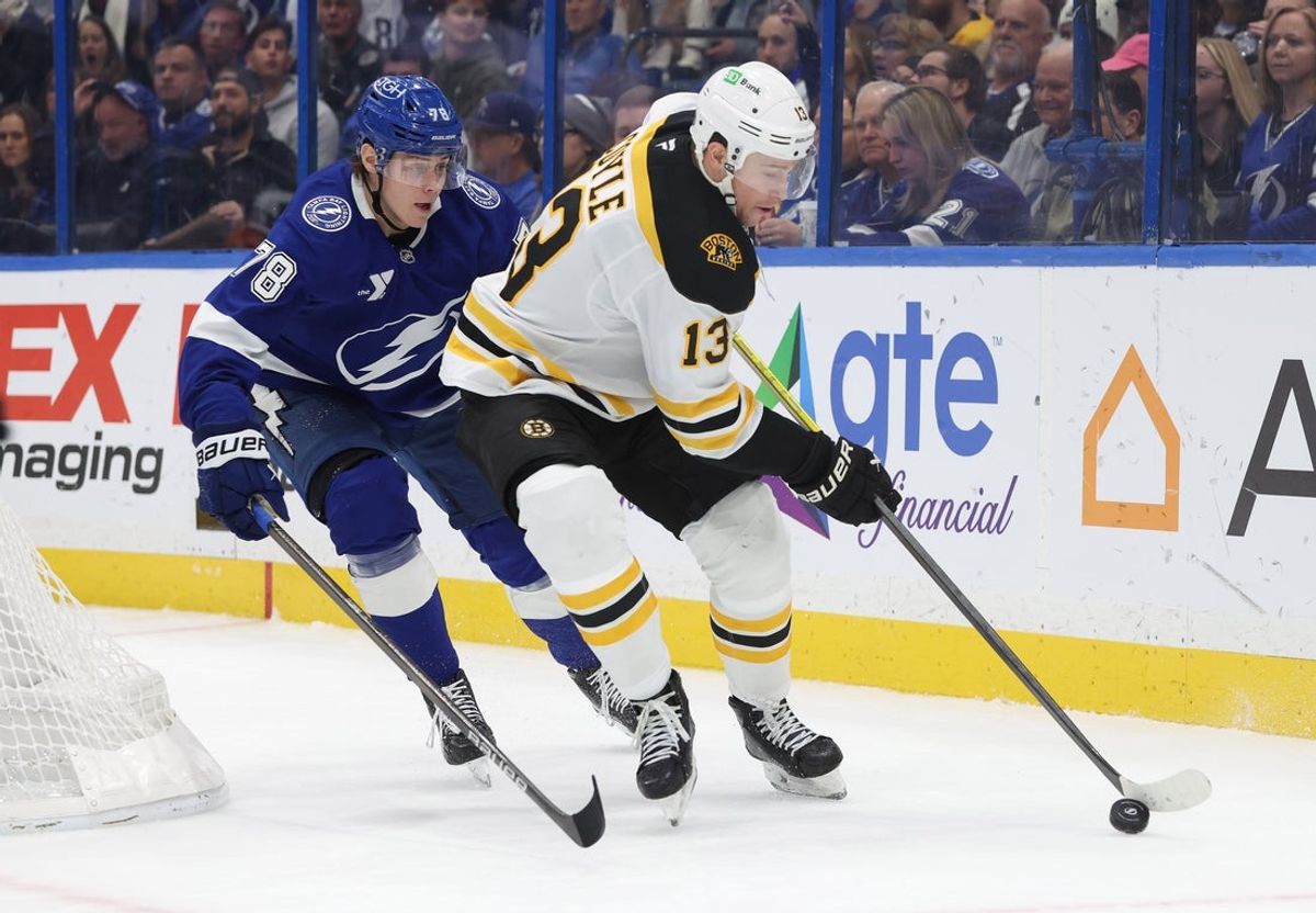 Jan 9, 2025; Tampa, Florida, USA; Boston Bruins center Charlie Coyle (13) skates with the puck as Tampa Bay Lightning defenseman Emil Lilleberg (78) defends during the second period at Amalie Arena. Mandatory Credit: Kim Klement Neitzel-Imagn Images