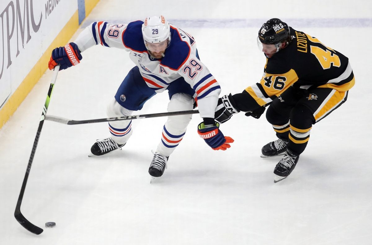 Jan 9, 2025; Pittsburgh, Pennsylvania, USA;  Edmonton Oilers center Leon Draisaitl (29) moves the puck against pressure from Pittsburgh Penguins center Blake Lizotte (46) during the third period at PPG Paints Arena. Mandatory Credit: Charles LeClaire-Imagn Images