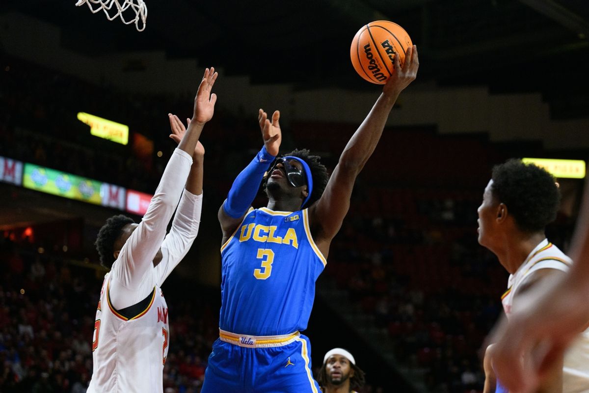 Jan 10, 2025; College Park, Maryland, USA;  UCLA Bruins guard Eric Dailey Jr. (3) takes a shot over Maryland Terrapins center Derik Queen (25) during the first half at Xfinity Center. Mandatory Credit: Reggie Hildred-Imagn Images