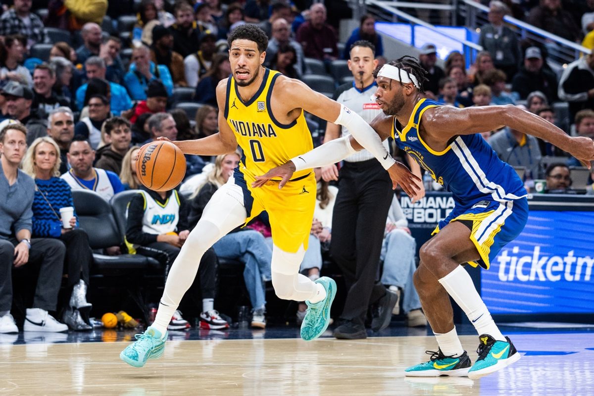 Jan 10, 2025; Indianapolis, Indiana, USA; Indiana Pacers guard Tyrese Haliburton (0) dribbles the ball while Golden State Warriors guard Buddy Hield (7) defends in the second half at Gainbridge Fieldhouse. Mandatory Credit: Trevor Ruszkowski-Imagn Images