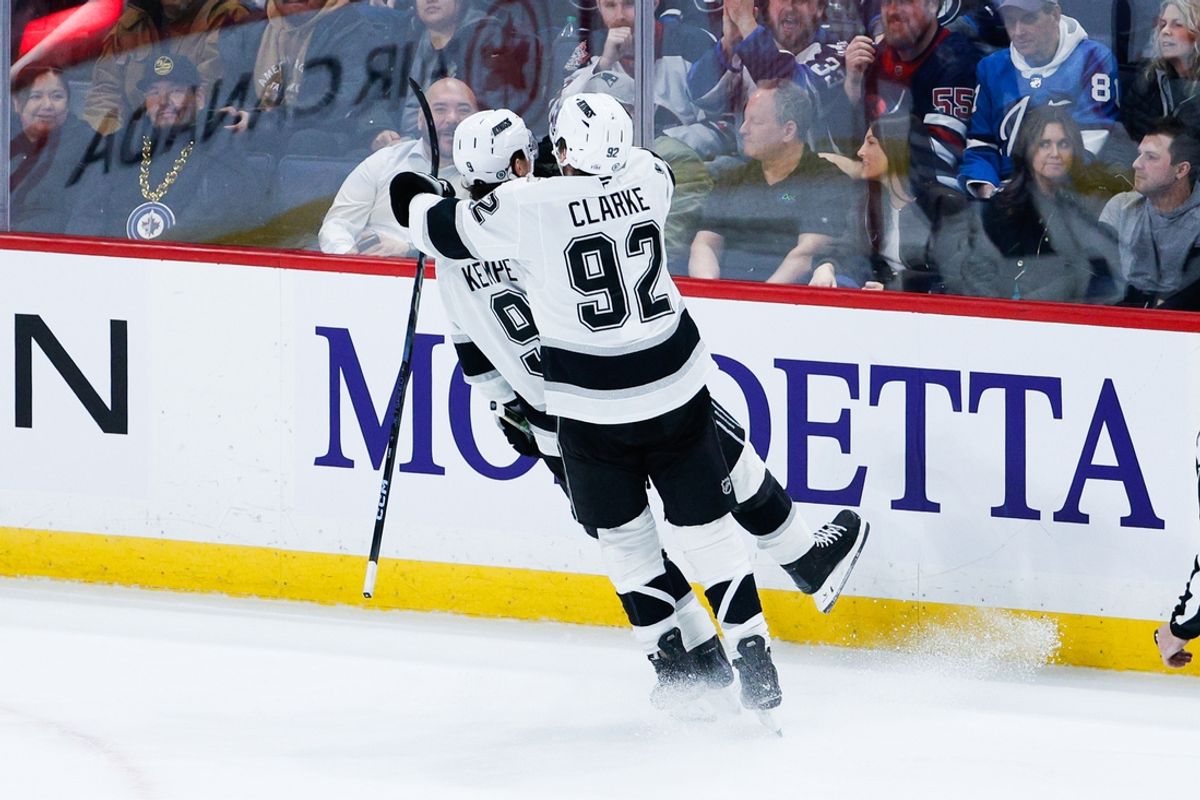 Jan 10, 2025; Winnipeg, Manitoba, CAN; Los Angeles Kings forward Adrian Kempe (9) is congratulated by Los Angeles Kings defenseman Brandt Clarke (92) on his goal against Winnipeg Jets goalie Eric Comrie (1) during the overtime period at Canada Life Centre. Mandatory Credit: Terrence Lee-Imagn Images