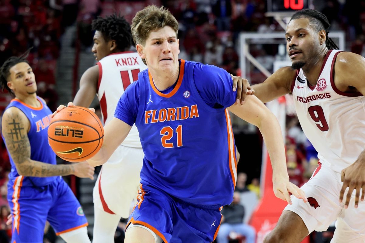Jan 11, 2025; Fayetteville, Arkansas, USA; Florida Gators forward Alex Condon (21) drives against Arkansas Razorbacks forward Jonas Aidoo (9) in the second half at Bud Walton Arena. Florida won 71-63. Mandatory Credit: Nelson Chenault-Imagn Images