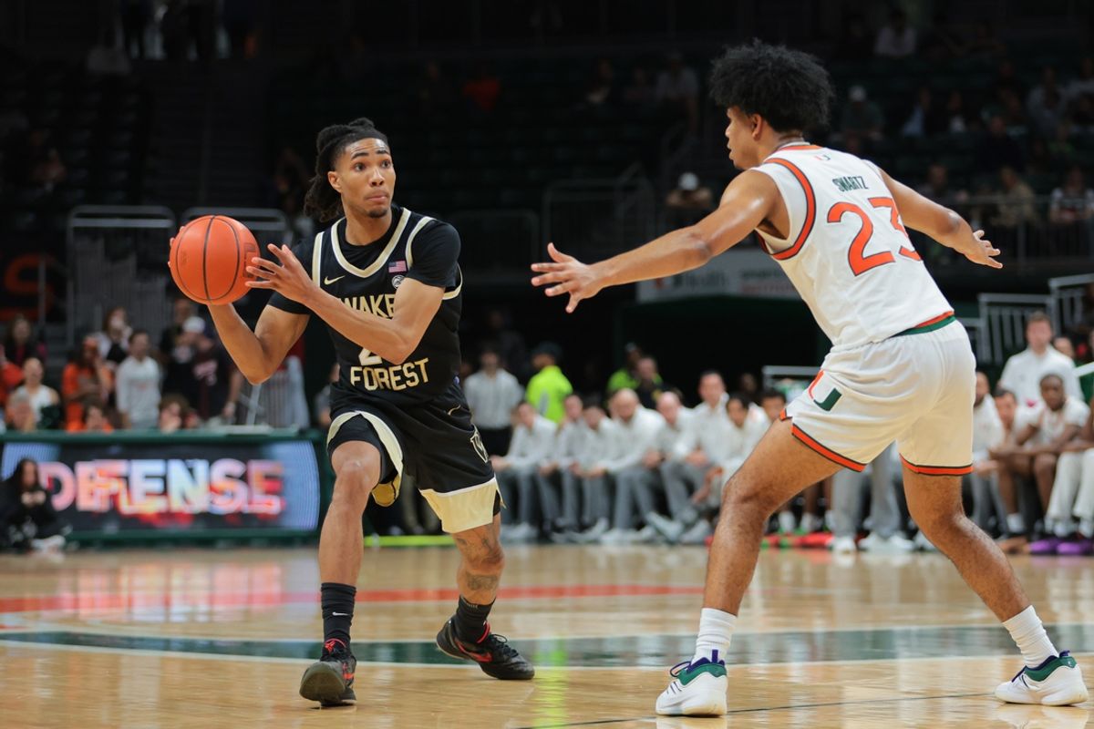 Jan 11, 2025; Coral Gables, Florida, USA; Wake Forest Demon Deacons guard Hunter Sallis (23) passes the basketball as Miami Hurricanes guard Austin Swartz (23) defends during the second half at Watsco Center. Mandatory Credit: Sam Navarro-Imagn Images