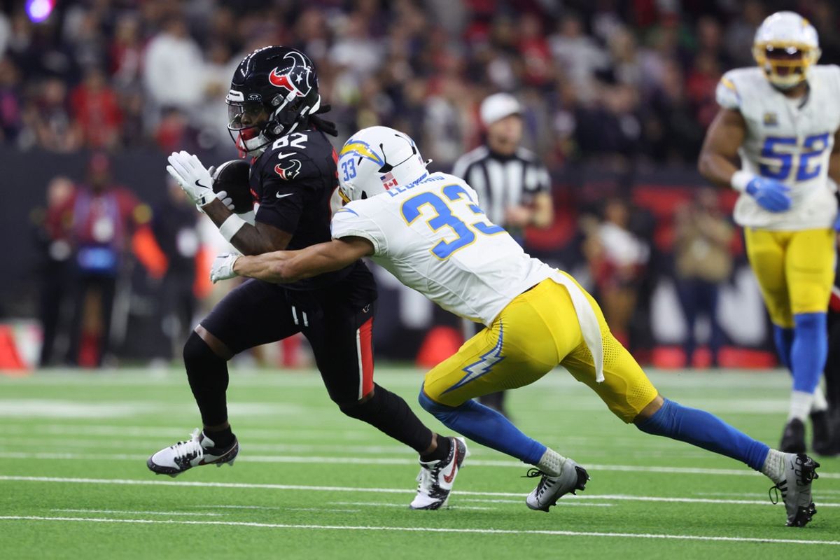 Jan 11, 2025; Houston, Texas, USA; Houston Texans wide receiver Diontae Johnson (82) reception against Los Angeles Chargers defensive back Deane Leonard (33) during the third quarter in an AFC wild card game at NRG Stadium. Mandatory Credit: Troy Taormina-Imagn Images