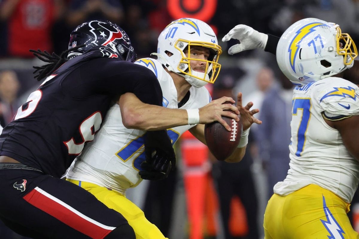 Jan 11, 2025; Houston, Texas, USA; Los Angeles Chargers quarterback Justin Herbert (10) is sacked by Houston Texans defensive end Denico Autry (96) during the third quarter in an AFC wild card game at NRG Stadium. Mandatory Credit: Troy Taormina-Imagn Images