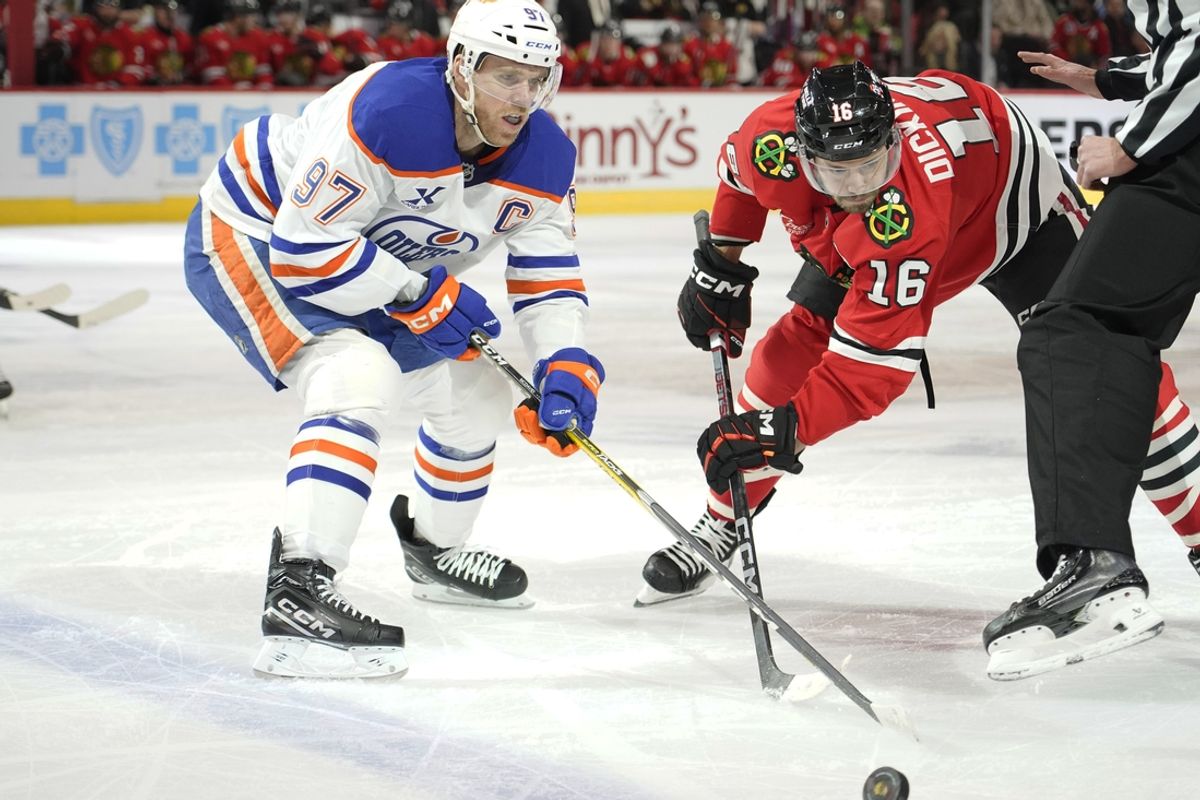 Jan 11, 2025; Chicago, Illinois, USA; Edmonton Oilers center Connor McDavid (97) and Chicago Blackhawks center Jason Dickinson (16) go for the puck during the first period at United Center. Mandatory Credit: David Banks-Imagn Images
