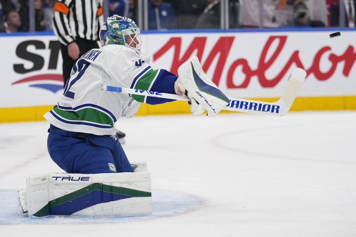 Jan 11, 2025; Toronto, Ontario, CAN; Vancouver Canucks goaltender Kevin Lankinen (32) deflects a puck against the Toronto Maple Leafs during the first period at Scotiabank Arena. Mandatory Credit: John E. Sokolowski-Imagn Images