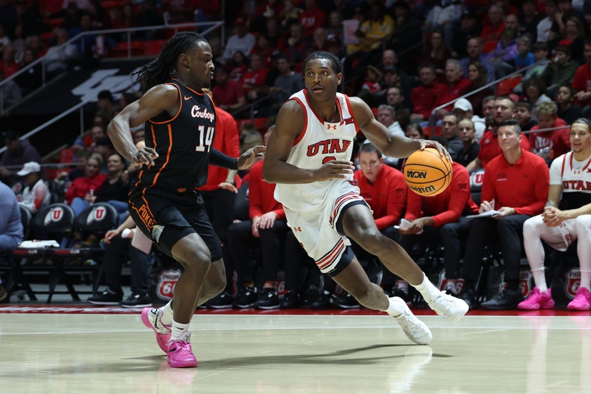 Jan 11, 2025; Salt Lake City, Utah, USA; Utah Utes forward Ezra Ausar (2) drives against Oklahoma State Cowboys guard Jamyron Keller (14) during the second half at Jon M. Huntsman Center. Mandatory Credit: Rob Gray-Imagn Images