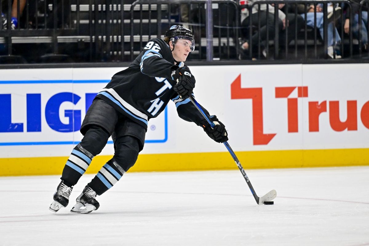 Jan 11, 2025; Salt Lake City, Utah, USA; Utah Hockey Club center Logan Cooley (92) moves the puck against the New York Islanders during first period at the Delta Center. Mandatory Credit: Christopher Creveling-Imagn Images
