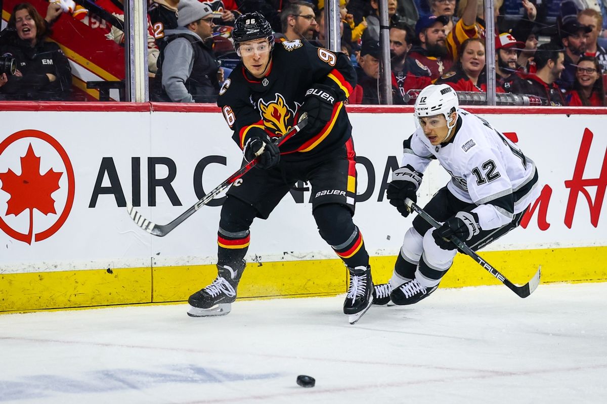Jan 11, 2025; Calgary, Alberta, CAN; Calgary Flames left wing Andrei Kuzmenko (96) passes the puck against Los Angeles Kings left wing Trevor Moore (12) during the first period at Scotiabank Saddledome. Mandatory Credit: Sergei Belski-Imagn Images