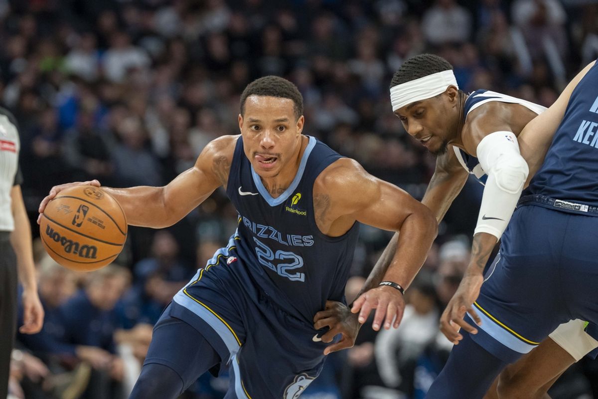 Jan 11, 2025; Minneapolis, Minnesota, USA; Memphis Grizzlies guard Desmond Bane (22) dribbles the ball against Minnesota Timberwolves forward Jaden McDaniels (3) in the second half at Target Center. Mandatory Credit: Jesse Johnson-Imagn Images
