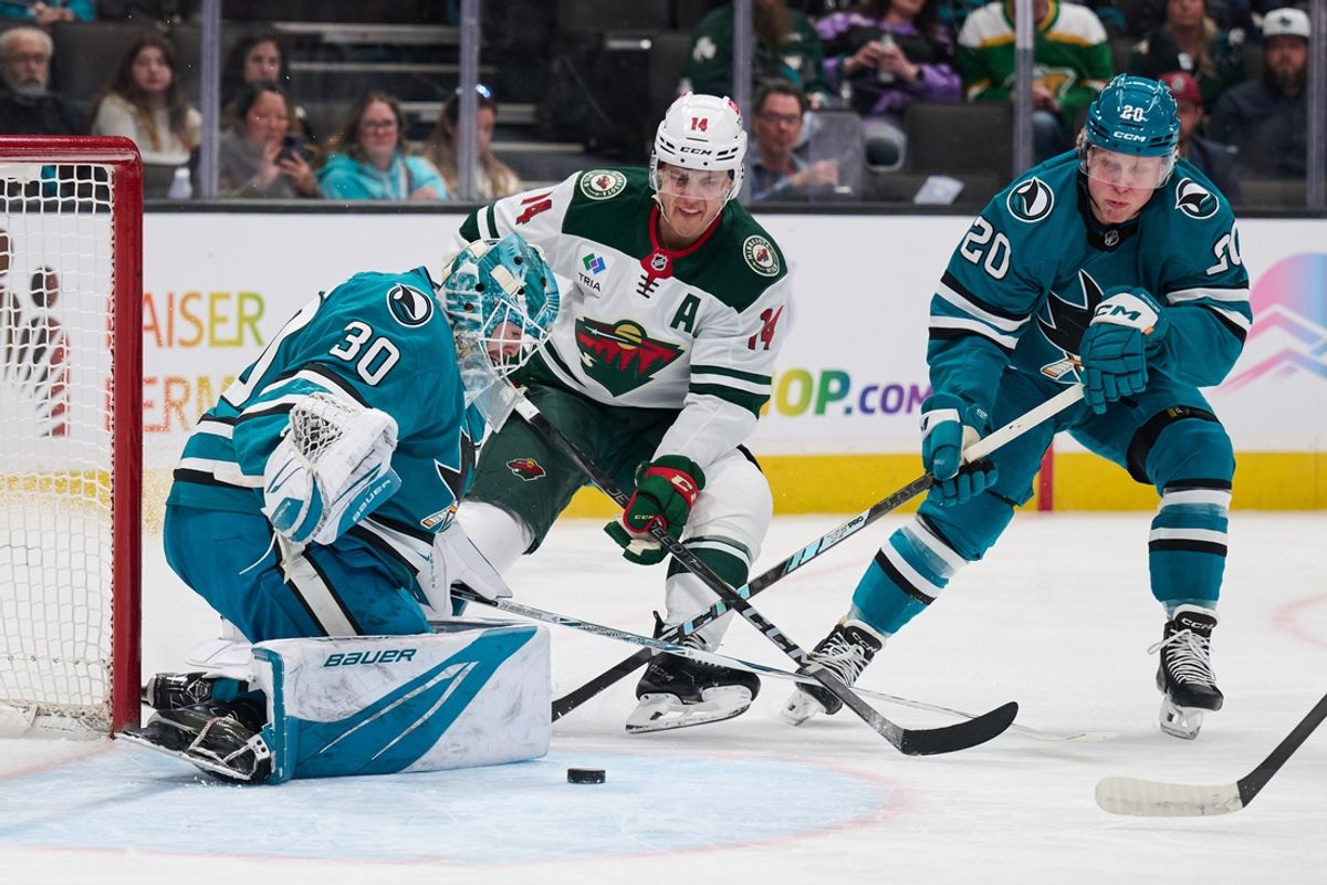 Jan 11, 2025; San Jose, California, USA; Minnesota Wild center Joel Eriksson Ek (14) shoots the puck against San Jose Sharks goaltender Yaroslav Askarov (30) and left wing Fabian Zetterlund (20) during the first period at SAP Center at San Jose. Mandatory Credit: Robert Edwards-Imagn Images