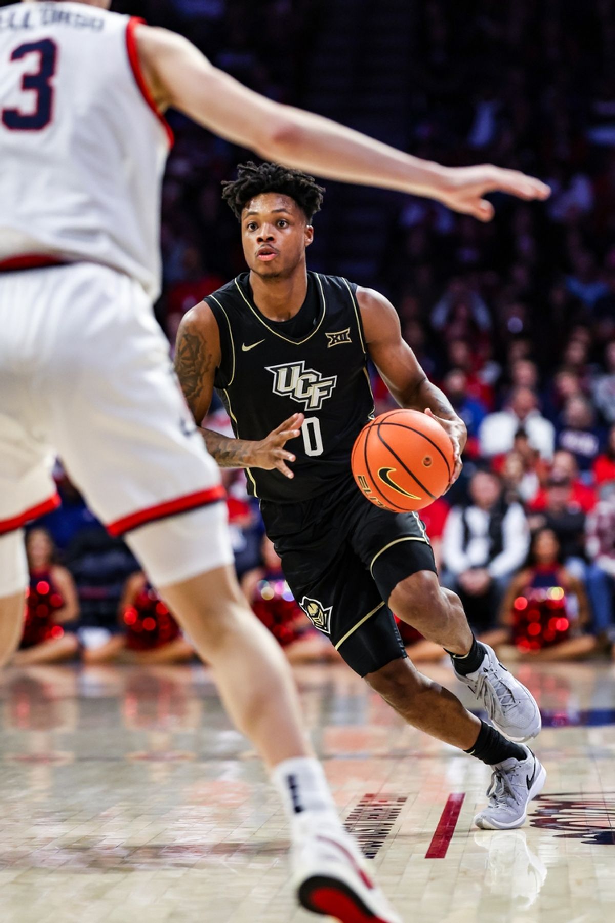 Jan 11, 2025; Tucson, Arizona, USA; UCF Knights guard Jordan Ivy-Curry (0) dribbles the ball while Arizona Wildcats guard Anthony Dell’Orso (3) stands ready during the first half of the game at McKale Center. Mandatory Credit: Aryanna Frank-Imagn Images