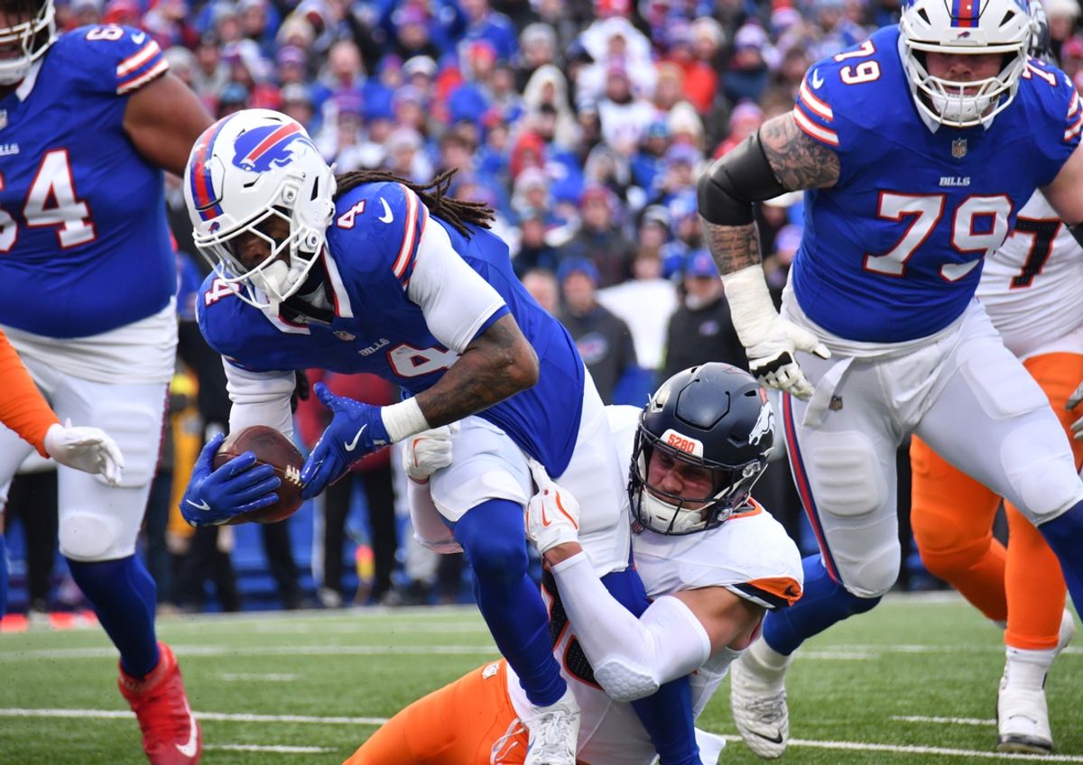 Jan 12, 2025; Orchard Park, New York, USA; Buffalo Bills running back James Cook (4) dives for a touchdown as Denver Broncos linebacker Cody Barton (55) tackles during the second quarter in an AFC wild card game at Highmark Stadium. Mandatory Credit: Mark Konezny-Imagn Images