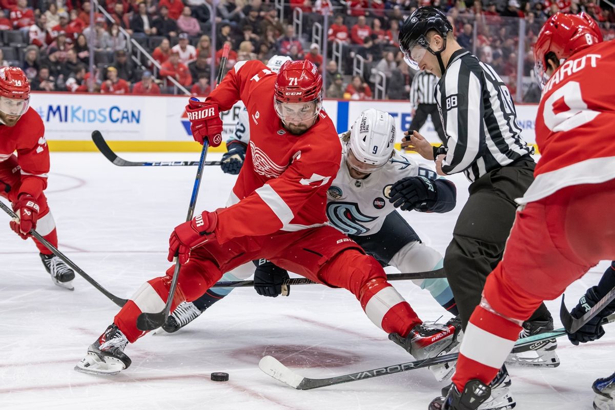 Jan 12, 2025; Detroit, Michigan, USA;  Detroit Red Wings forward Dylan Larkin (71) beats Seattle Kraken forward Chandler Stephenson (9) on a face-off during the first period at Little Caesars Arena. Mandatory Credit: Nick Wosika-Imagn Images