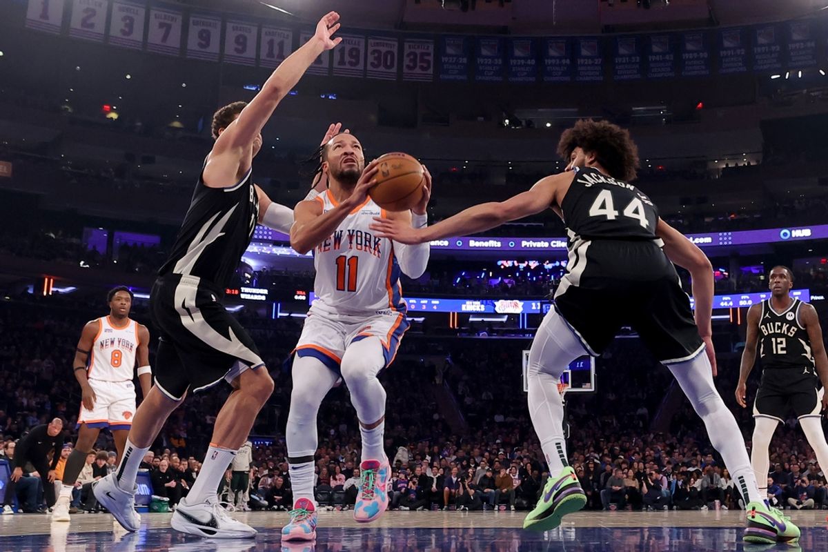 Jan 12, 2025; New York, New York, USA; New York Knicks guard Jalen Brunson (11) drives to the basket against Milwaukee Bucks center Brook Lopez (11) and guard Andre Jackson Jr. (44) during the first quarter at Madison Square Garden. Mandatory Credit: Brad Penner-Imagn Images