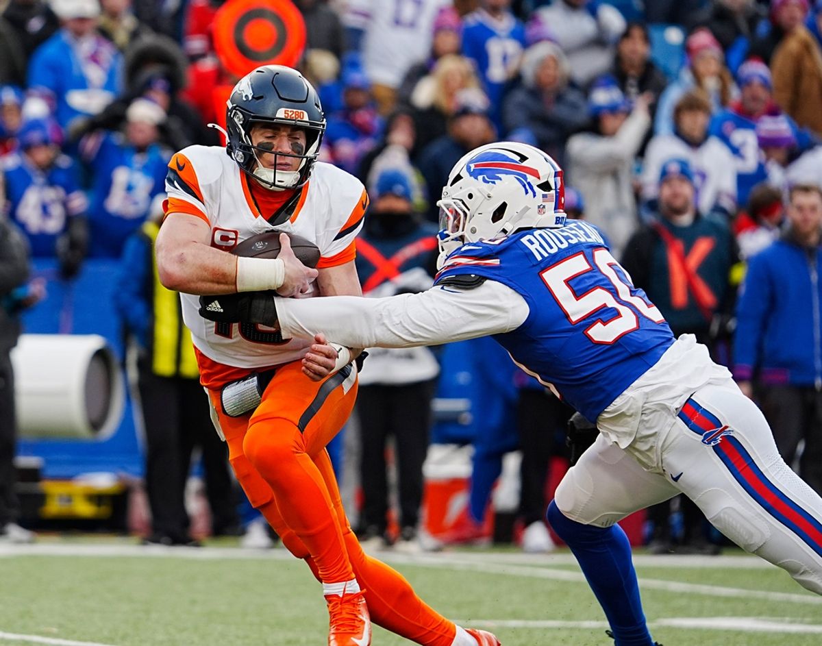 Denver Broncos quarterback Bo Nix (10) gets grabbed by and then sacked by Buffalo Bills defensive end Greg Rousseau (50) during the second half of the Buffalo Bills wild card game against the Denver Broncos at Highmark Stadium in Orchard Park on Jan. 12, 2025.