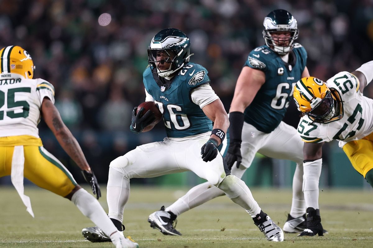 Jan 12, 2025; Philadelphia, Pennsylvania, USA; Philadelphia Eagles running back Saquon Barkley (26) rushes the ball against Green Bay Packers cornerback Keisean Nixon (25) in the fourth quarter in an NFC wild card game at Lincoln Financial Field. Mandatory Credit: Bill Streicher-Imagn Images