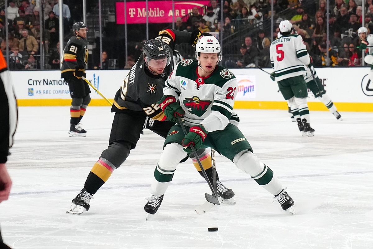 Jan 12, 2025; Las Vegas, Nevada, USA; Minnesota Wild center Marco Rossi (23) skates ahead of Vegas Golden Knights right wing Cole Schwindt (22) during the first period at T-Mobile Arena. Mandatory Credit: Stephen R. Sylvanie-Imagn Images