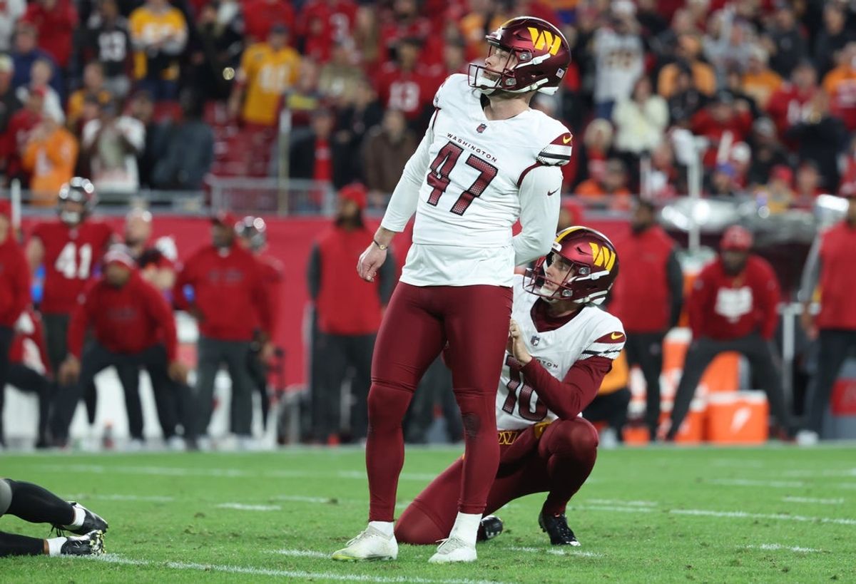 Jan 12, 2025; Tampa, Florida, USA; Washington Commanders place kicker Zane Gonzalez (47) kicks the game-winning field goal out of the hold of punter Tress Way (10) during the fourth quarter of a NFC wild card playoff against the Tampa Bay Buccaneers at Raymond James Stadium. Mandatory Credit: Kim Klement Neitzel-Imagn Images