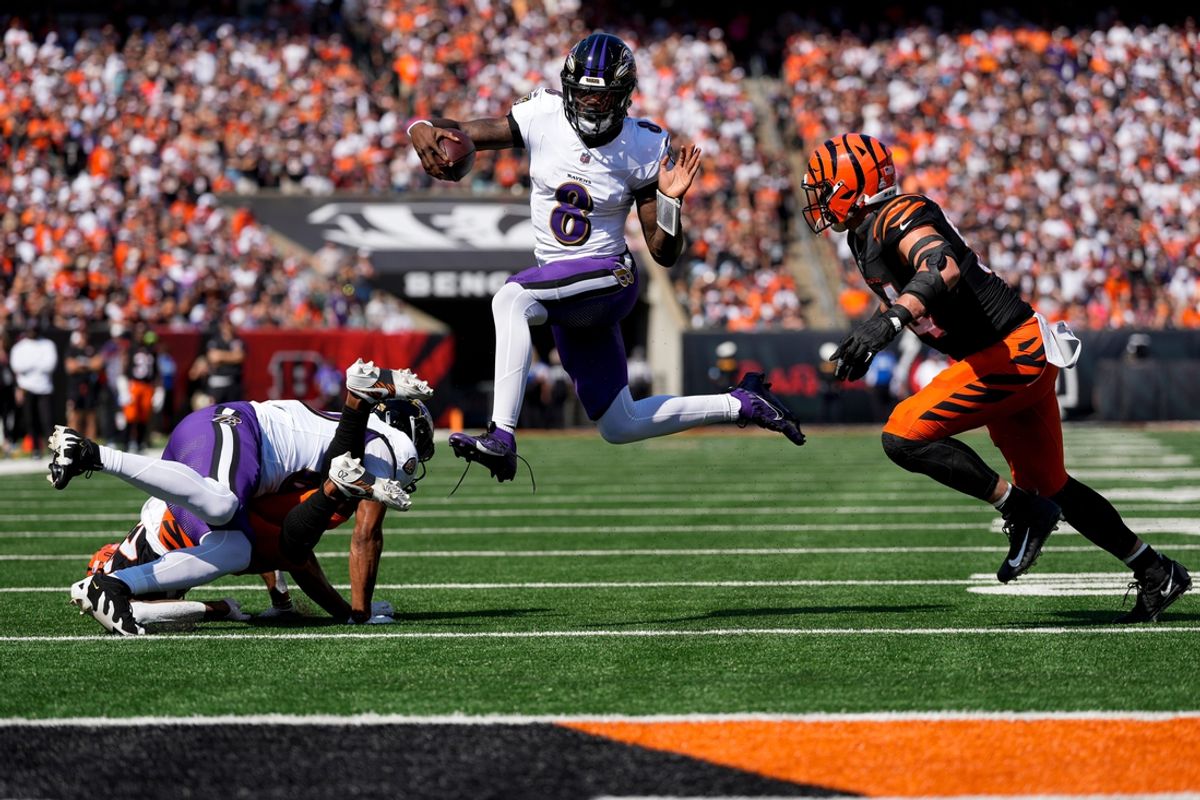 Baltimore Ravens quarterback Lamar Jackson (8) leaps away from Cincinnati Bengals defensive end Sam Hubbard (94) in the first quarter of the NFL Week 5 game between the Cincinnati Bengals and Baltimore Ravens at Paycor Stadium in Cincinnati on Oct. 6, 2024.