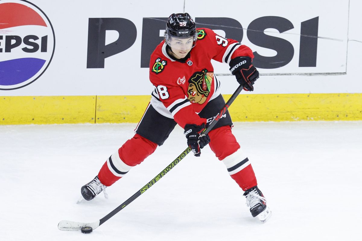 Jan 13, 2025; Chicago, Illinois, USA; Chicago Blackhawks center Connor Bedard (98) passes the puck against the Calgary Flames during the second period at United Center. Mandatory Credit: Kamil Krzaczynski-Imagn Images