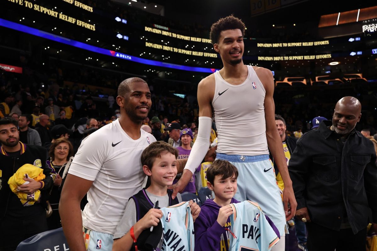 Jan 13, 2025; Los Angeles, California, USA;  San Antonio Spurs guard Chris Paul (3, left) and center Victor Wembanyama (1,right) pose for a photo with Los Angeles Lakers head coach JJ Redick's sons after defeating the Lakers 126-102 at Crypto.com Arena. Mandatory Credit: Kiyoshi Mio-Imagn Images