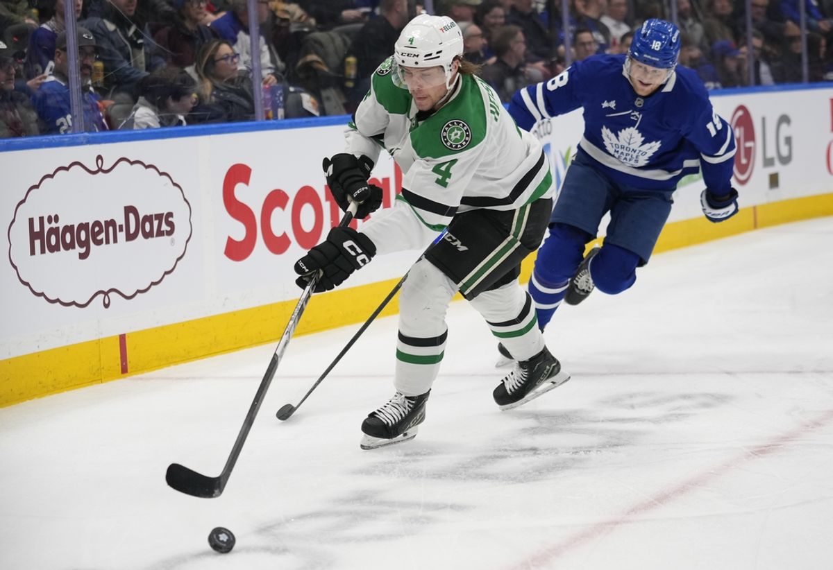Jan 14, 2025; Toronto, Ontario, CAN; Dallas Stars defenseman Miro Heiskanen (4) clears the puck as Toronto Maple Leafs forward Steven Lorentz (18) closes in during the first period at Scotiabank Arena. Mandatory Credit: John E. Sokolowski-Imagn Images