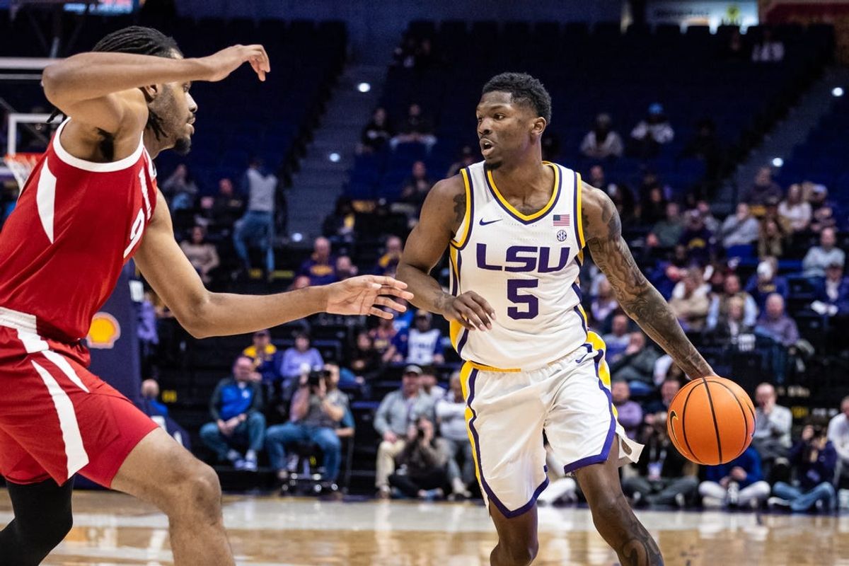 Jan 14, 2025; Baton Rouge, Louisiana, USA;  LSU Tigers guard Cam Carter (5) dribbles against Arkansas Razorbacks forward Jonas Aidoo (9) during the first half at Pete Maravich Assembly Center. Mandatory Credit: Stephen Lew-Imagn Images