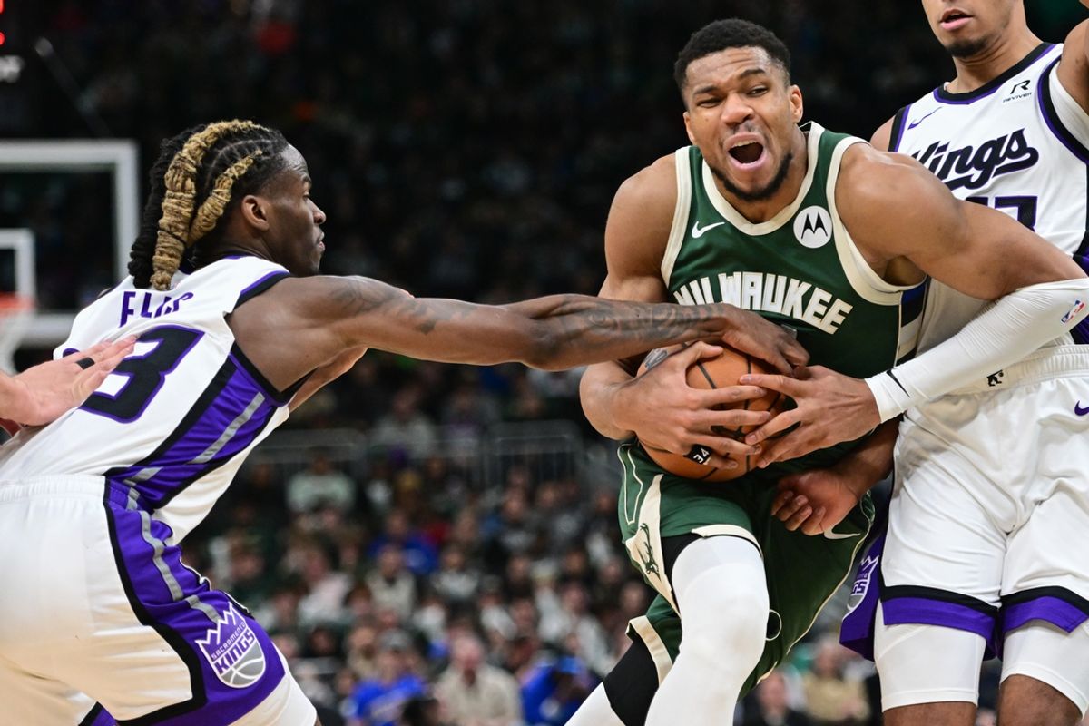 Jan 14, 2025; Milwaukee, Wisconsin, USA; Milwaukee Bucks forward Giannis Antetokounmpo (34) keeps the ball away from Sacramento Kings forward Keegan Murray (13) in the fourth quarter at Fiserv Forum. Mandatory Credit: Benny Sieu-Imagn Images