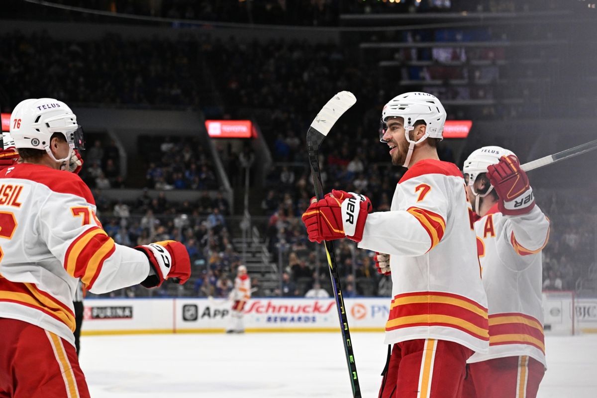 Jan 14, 2025; St. Louis, Missouri, USA; Calgary Flames defenseman Kevin Bahl (7) is congratulated after scoring a goal against the St. Louis Blues in the third period at Enterprise Center. Mandatory Credit: Joe Puetz-Imagn Images