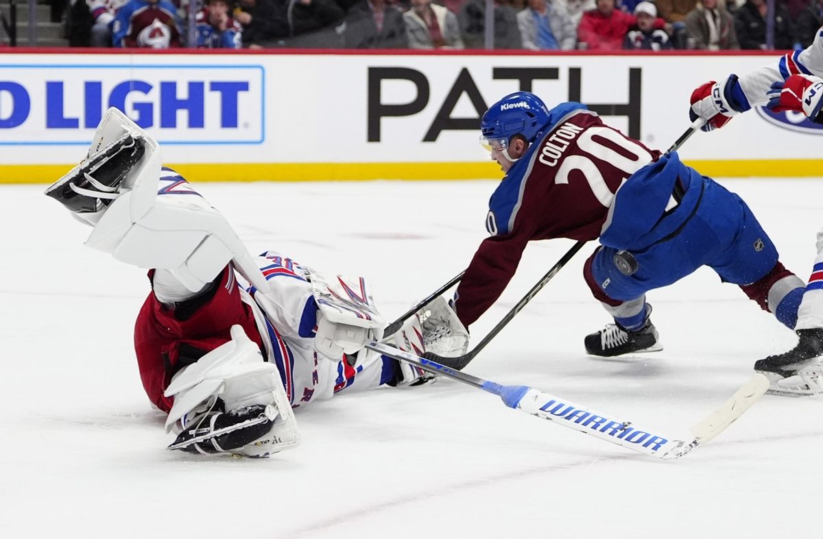 Jan 14, 2025; Denver, Colorado, USA; Colorado Avalanche center Ross Colton (20) collides into New York Rangers goaltender Igor Shesterkin (31) in the second period at Ball Arena. Mandatory Credit: Ron Chenoy-Imagn Images