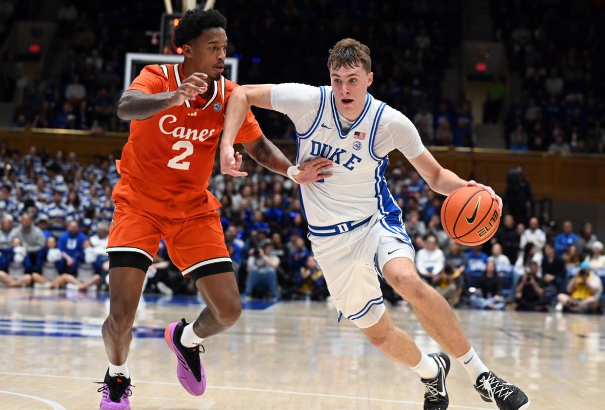 Jan 14, 2025; Durham, North Carolina, USA; Duke Blue Devils forward Cooper Flagg (2) drives to the basket as Miami Hurricanes forward Brandon Johnson (2) defends during the second half at Cameron Indoor Stadium. Mandatory Credit: Rob Kinnan-Imagn Images
