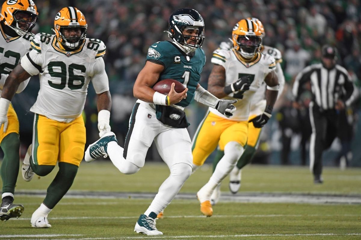 Jan 12, 2025; Philadelphia, Pennsylvania, USA; Philadelphia Eagles quarterback Jalen Hurts (1) runs past Green Bay Packers defensive tackle Colby Wooden (96) in an NFC wild card game at Lincoln Financial Field. Mandatory Credit: Eric Hartline-Imagn Images
