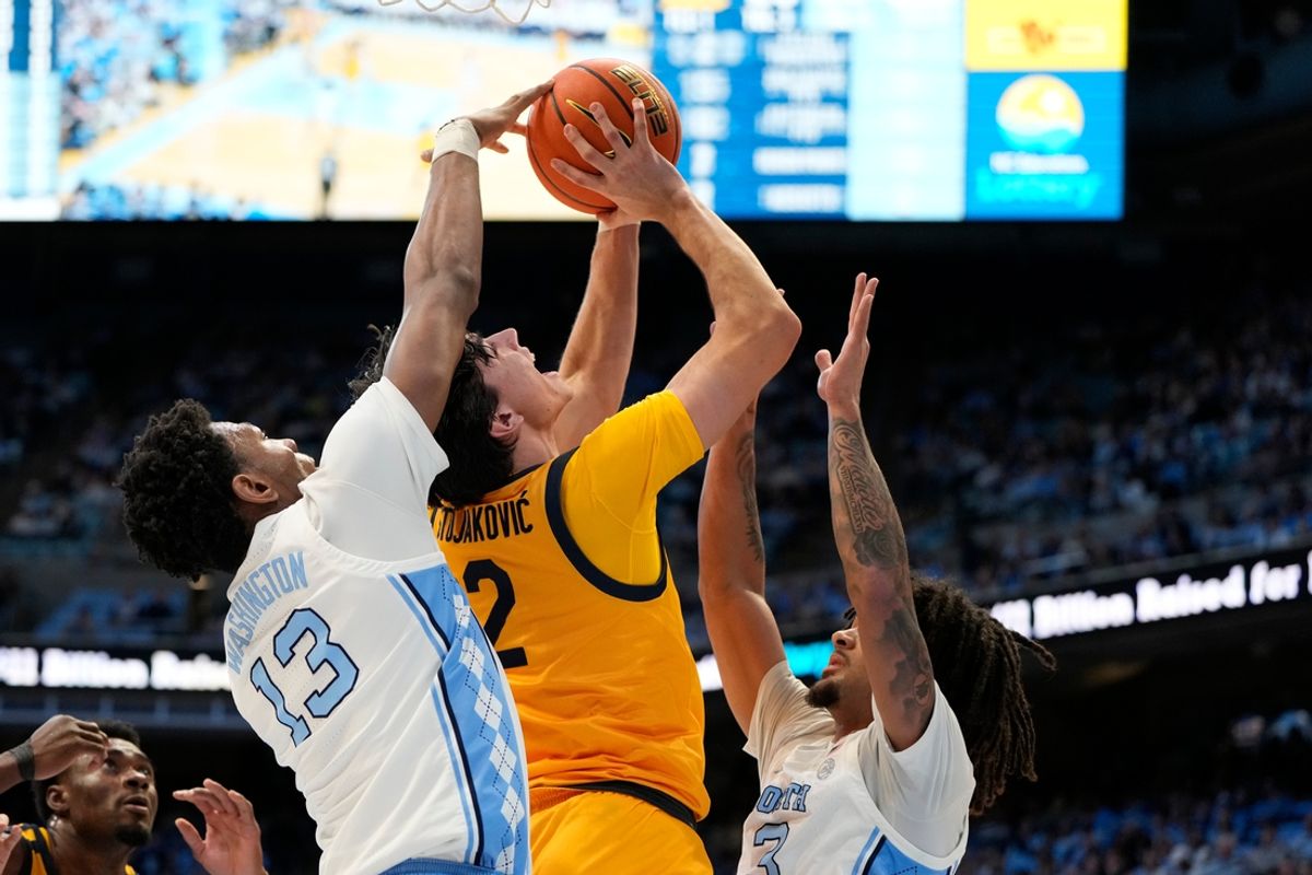 Jan 15, 2025; Chapel Hill, North Carolina, USA; North Carolina Tar Heels forward Jalen Washington (13) blocks the shot of California Golden Bears guard Andrej Stojakovic (2) as guard Elliot Cadeau (3) helps defend in the first half at Dean E. Smith Center. Mandatory Credit: Bob Donnan-Imagn Images