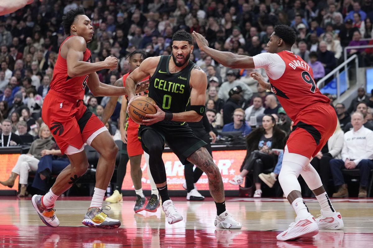 Jan 15, 2025; Toronto, Ontario, CAN; Boston Celtics forward Jayson Tatum (0) drives against Toronto Raptors forward Scottie Barnes (4) and guard RJ Barrett (9) during the first half at Scotiabank Arena. Mandatory Credit: John E. Sokolowski-Imagn Images