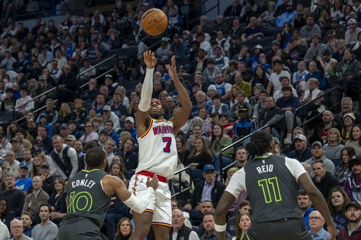 Jan 15, 2025; Minneapolis, Minnesota, USA; Golden State Warriors guard Buddy Hield (7) shoots the ball over Minnesota Timberwolves guard Mike Conley (10) and center Naz Reid (11) in the second half at Target Center. Mandatory Credit: Jesse Johnson-Imagn Images
