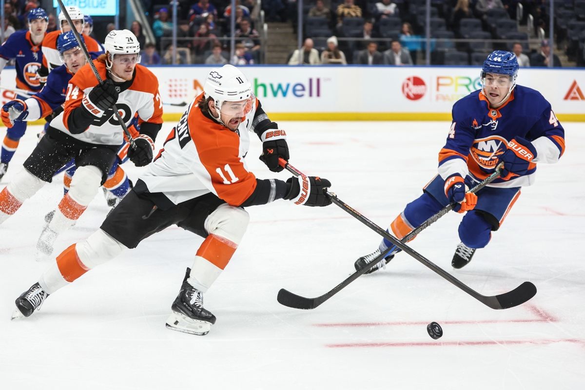 Jan 16, 2025; Elmont, New York, USA;  Philadelphia Flyers right wing Travis Konecny (11) passes the puck past New York Islanders center Jean-Gabriel Pageau (44) in the first period at UBS Arena. Mandatory Credit: Wendell Cruz-Imagn Images