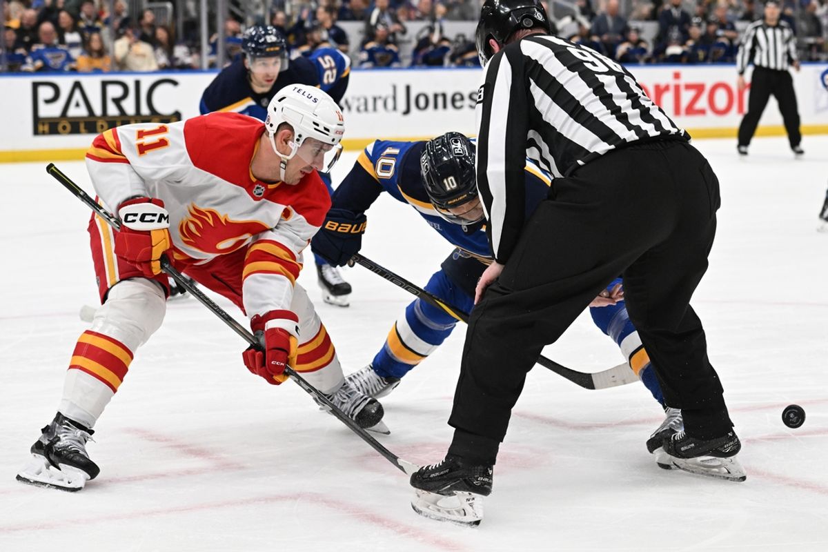 Jan 16, 2025; St. Louis, Missouri, USA; Calgary Flames center Mikael Backlund (11) faces off against St. Louis Blues center Brayden Schenn (10) in the second period at Enterprise Center. Mandatory Credit: Joe Puetz-Imagn Images